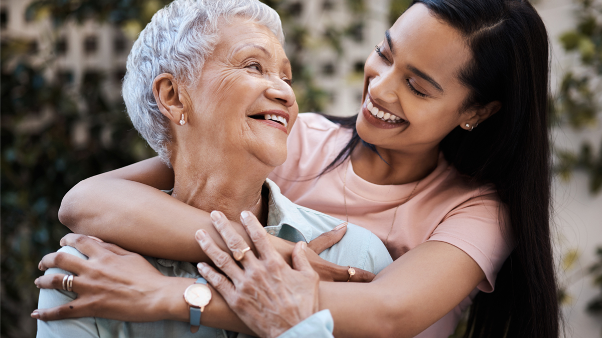 Younger woman with arms around older woman