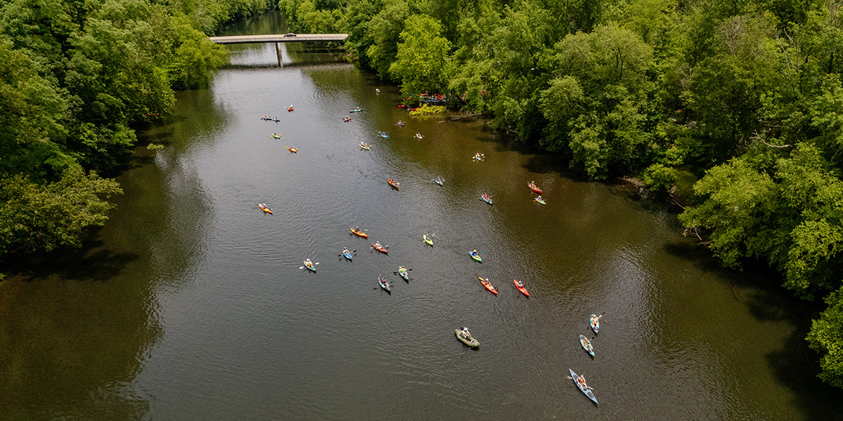 Drone photo shot from above the Schuylkill River as a group of paddlers sojourn down the river.