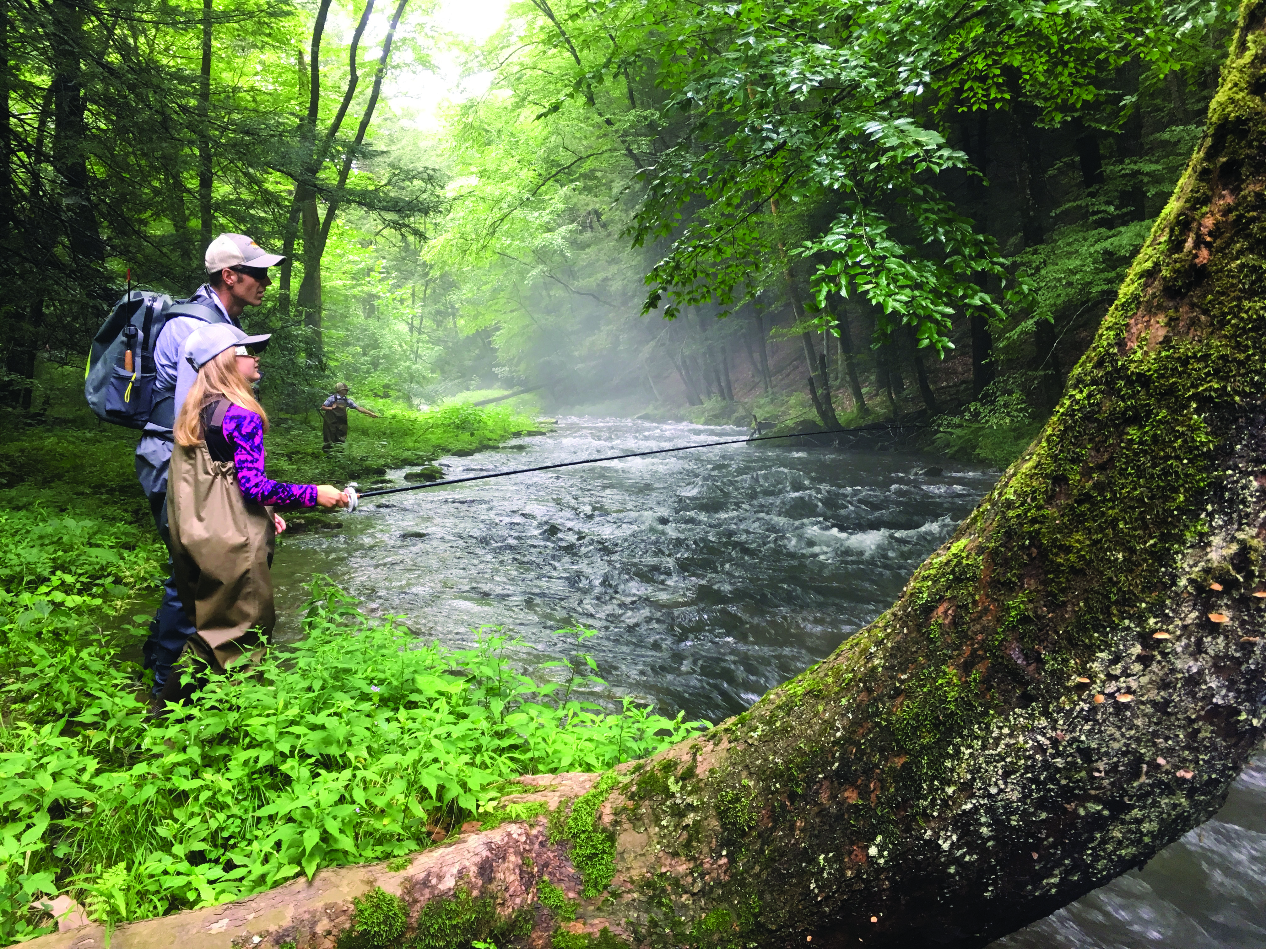 Father and daughter fishing on stream