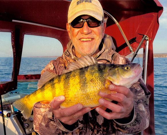 Kirk Rudzinski on a boat holding up his 3 lb. 0 oz Pennsylvania State Record Yellow Perch