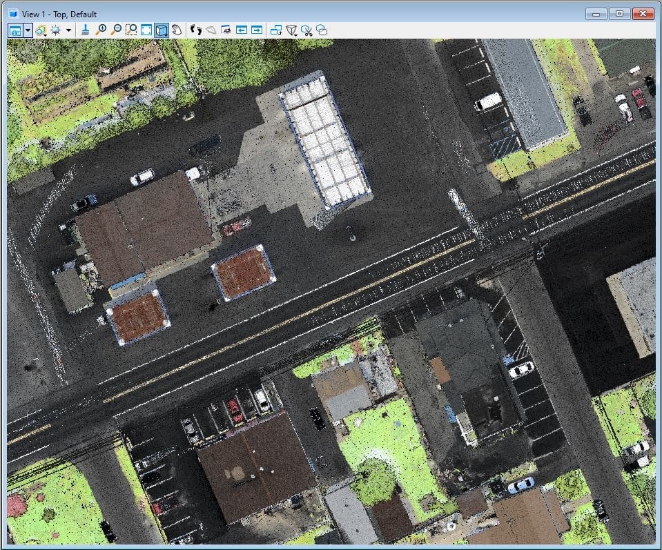 A drone-based LiDAR image, which is a tool to improve geospatial data collection, shows a two-lane roadway with large buildings and homes on either side of the roadway.