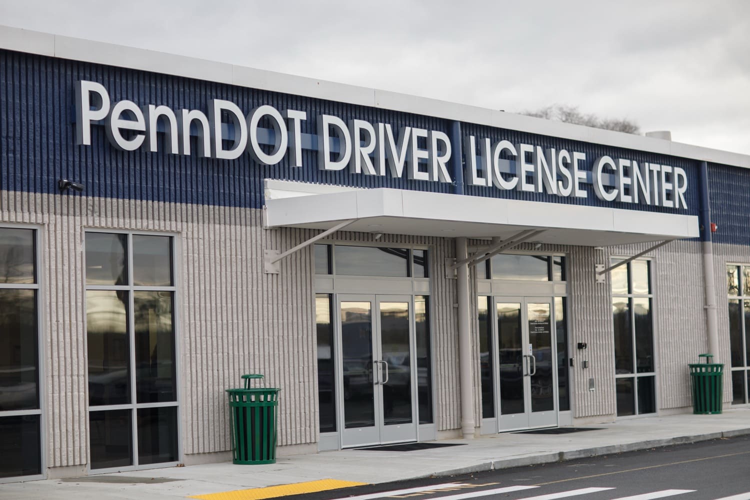 An image of a PennDOT Driver License Center. Large windows sit on either side of two, double-sided doors covered by an awning and the words 'PennDOT Driver License Center' above it.