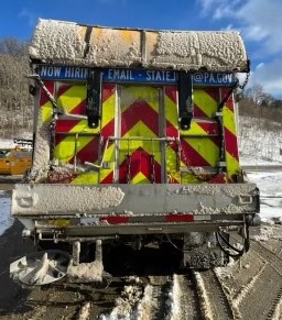 An image of a PennDOT plow truck with a large barrier mounted to the top to protect the truck from buildup and keep it clean.