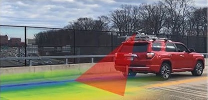 A red sports utility vehicle crossing a bridge uses infrared thermography to assess the condition of the bridge deck. 