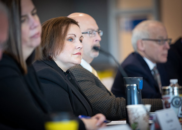 Woman in business suit at table with colleagues.