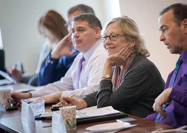Smiling woman in business attire at meeting.