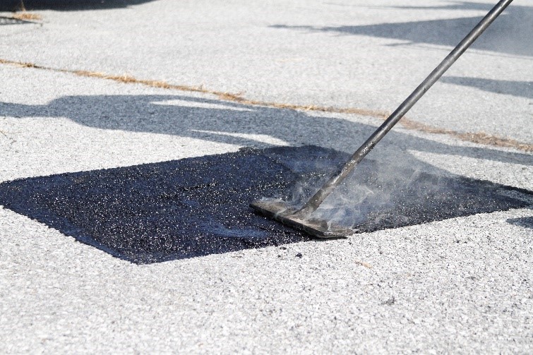 Highway maintenance worker applying hot pour mastics on a road.