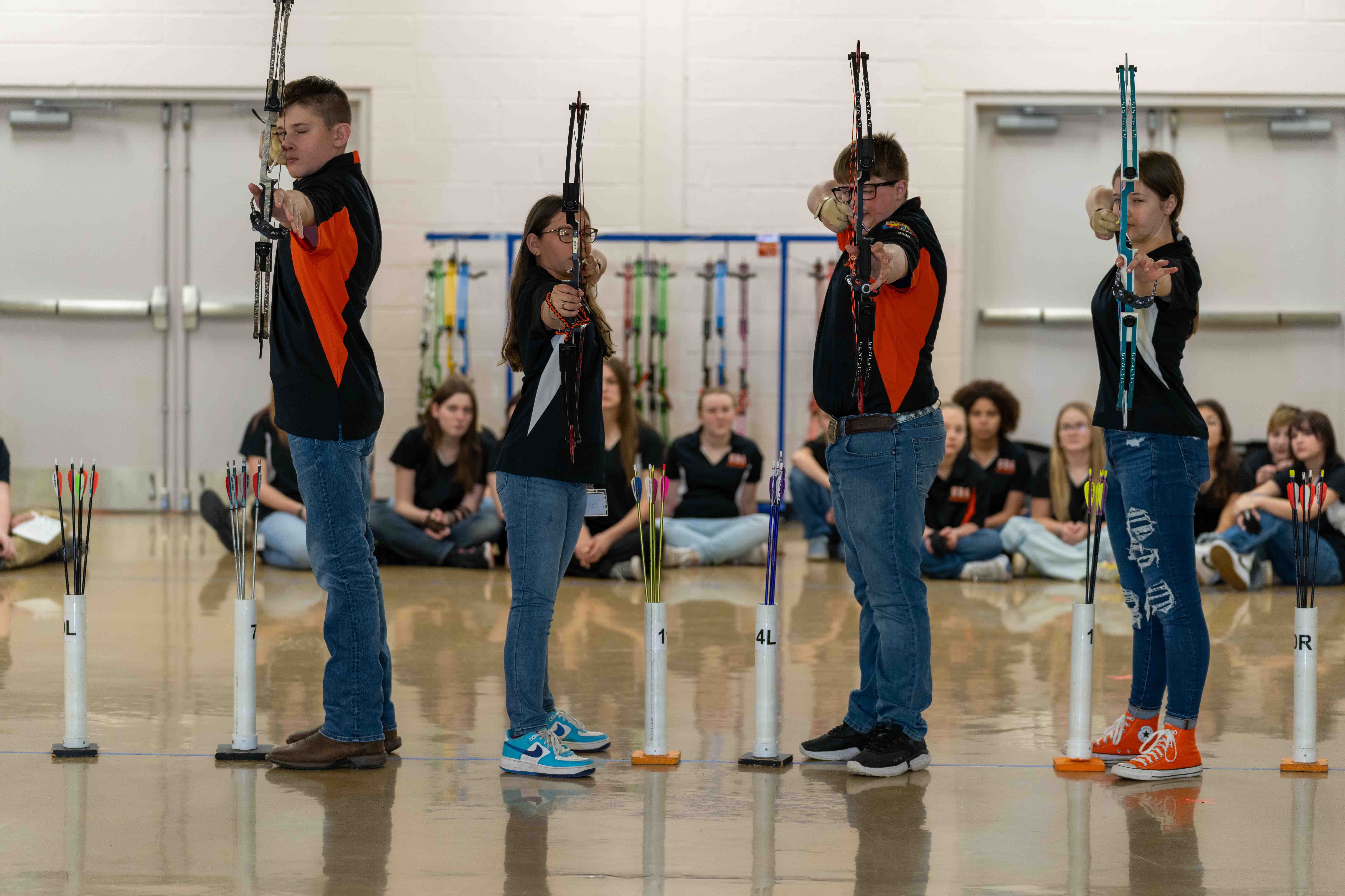 Student archers standing and holding bow and arrows