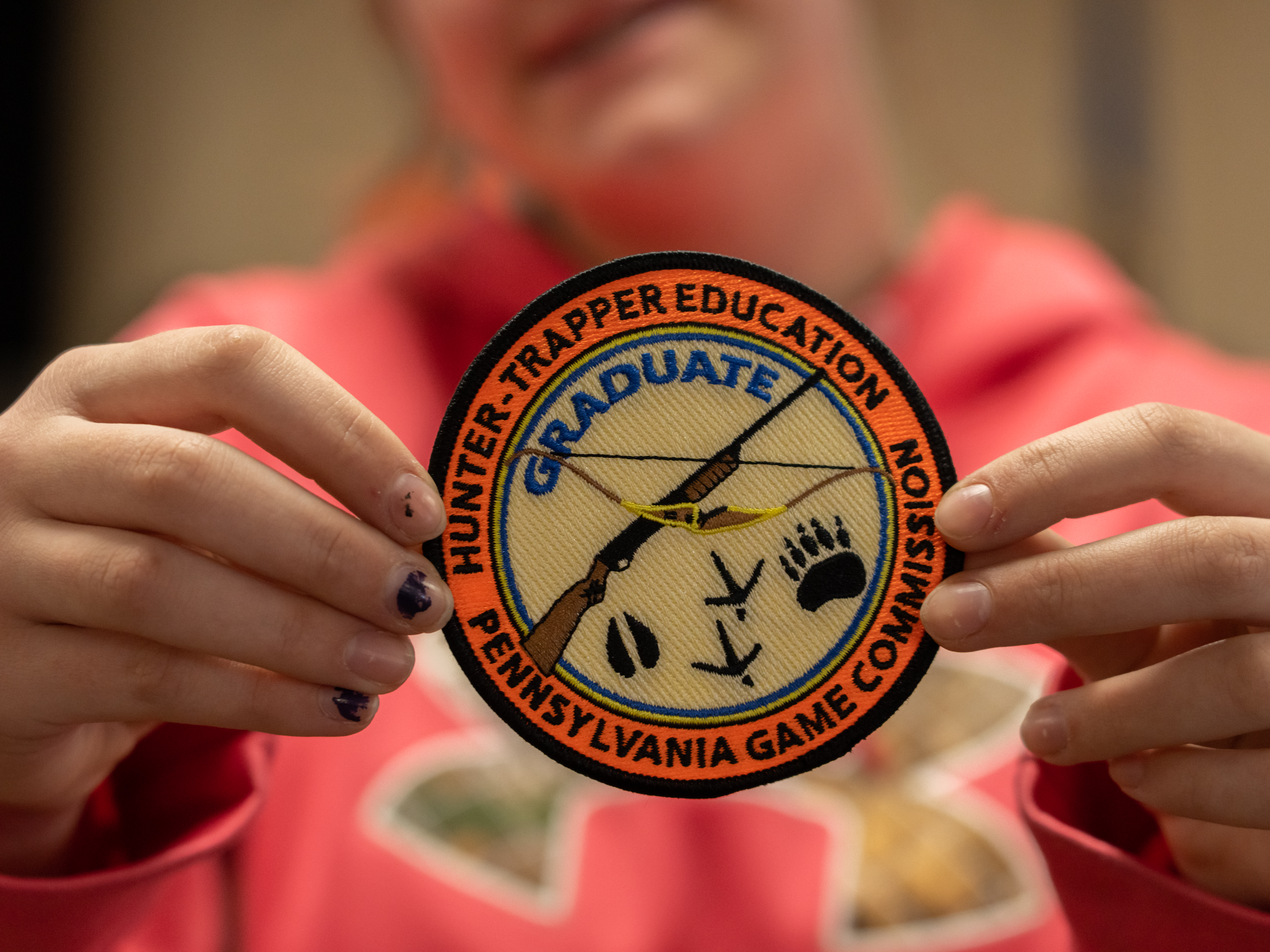 Hunter holding up a hunter trapper education patch