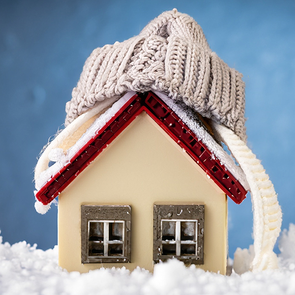 snowy weather with model of a house wearing a knitted cap