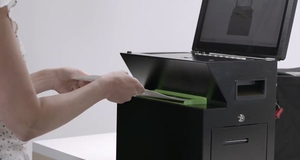 Person placing their ballot into the ballot scanner