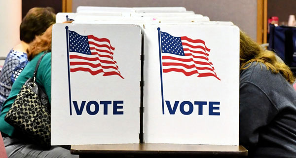 Voters voting in a voting booth